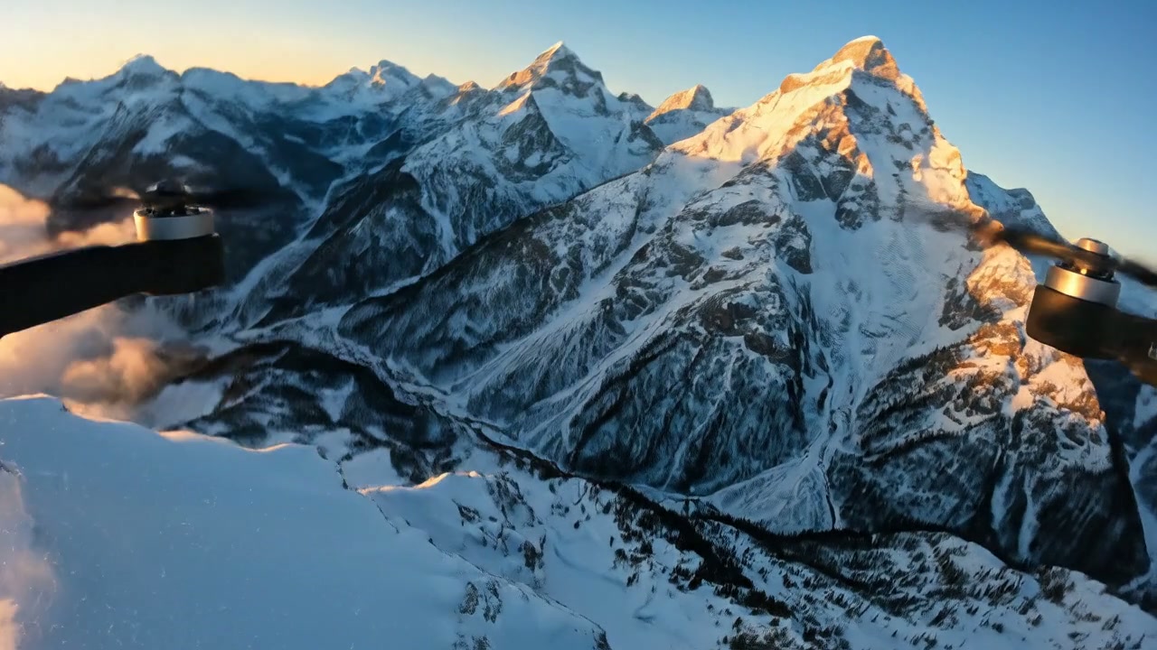 FPV drone flying through snow-covered mountain peaks at sunrise, sharp wind particles, dramatic camera swoop down the valley, then rising above clouds, cinematic IMAX shot, natural golden hour lighting, ultra-realistic detail, smooth motion, 4K filmmaking quality.